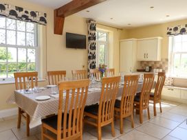 A dining room with a long table set with plates glasses and cutlery surrounded by wooden chairs at Foremans House in Bridlington