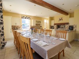 A kitchen with a long dining table set for meal with wooden chairs at Foremans House in Bridlington
