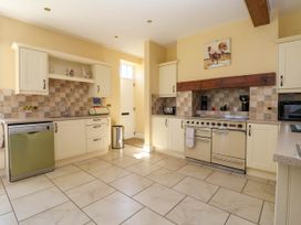 A kitchen with cream cabinets a dishwasher an oven a toaster and a sink at Foremans House in Bridlington