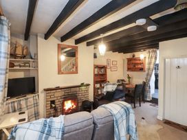 A living room with a fireplace and a television at Merlin in Llithfaen near Nefyn