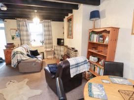 A living room with furniture including a sofa and dining table at Merlin near Llithfaen Nefyn
