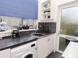 A kitchen with a washing machine and sink at Merlin in Llithfaen near Nefyn