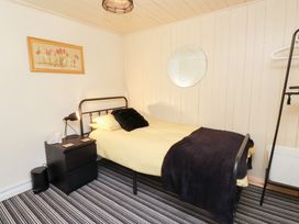 A bedroom with a bed and nightstand at Merlin in Llithfaen near Nefyn