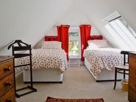 A bedroom with two beds and a window at Sisial y Llyn in Bala
