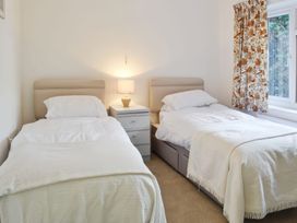 A bedroom with two single beds and a window at Sisial y Llyn in Bala
