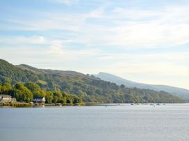 A scenic view of a lake with mountains and boats at Sisial y Llyn in Bala