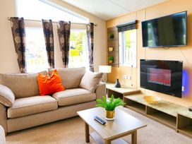 A living room with a sofa and television at Cheri in Southerness