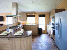A kitchen with appliances and dining set at Cheri in Southerness