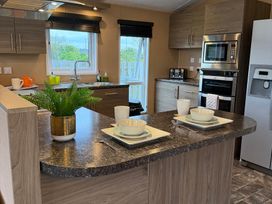 A kitchen with sink and appliances at Cheri in Southerness