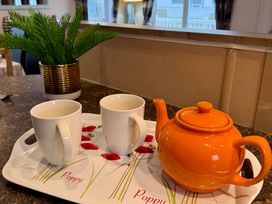 A kitchen setting with a teapot and mugs on a tray at Cheri Southerness