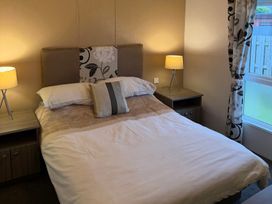A bedroom with a bed and lamps at Cheri in Southerness