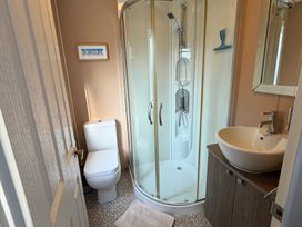 A bathroom with a shower, toilet, and sink at Cheri in Southerness
