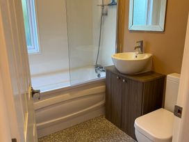 A bathroom with a bathtub, sink, and toilet at Cheri in Southerness