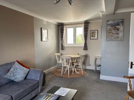 A living room with a dining table and chairs at Greenmantle in Skinburness near Silloth, Solway Firth