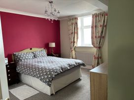 A bedroom with a double bed and bedside table at Greenmantle in Skinburness near Silloth, Solway Firth