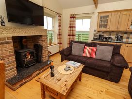 A living room with a fireplace and sofa at West Gate in Embleton