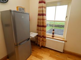 A kitchen with a refrigerator and window at West Gate in Embleton