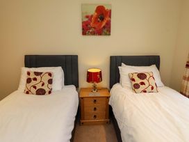 A bedroom with two single beds and a bedside table at West Gate in Embleton