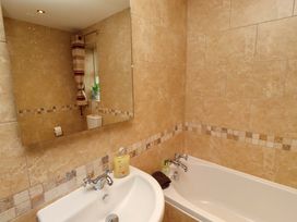 A bathroom with a bath and sink at West Gate in Embleton