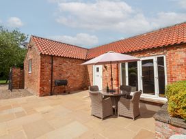 An outdoor seating area with a table and chairs at Winsall Court I Gransmoor near Bridlington