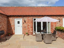 An outdoor seating area with a table and chairs at Winsall Court I Gransmoor near Bridlington