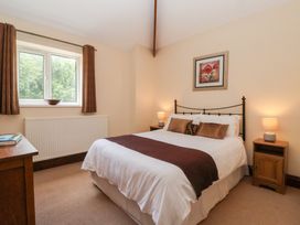 A bedroom with a bed, nightstand, and desk at Winsall Court I Gransmoor near Bridlington