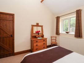 A bedroom with a bed, wooden furniture, and window at Winsall Court I near Gransmoor