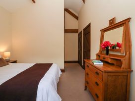 A bedroom with a bed and a dressing table at Winsall Court I Gransmoor near Bridlington