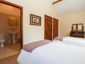 A bedroom with two beds and a bathroom entrance at Winsall Court I Gransmoor near Bridlington