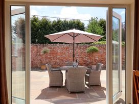 An outdoor seating area with a table and chairs under an umbrella at Winsall Court II Gransmoor near Bridlington