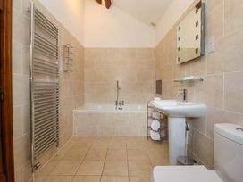 A bathroom with a bathtub, sink, and towel rack at Winsall Court II in Gransmoor near Bridlington