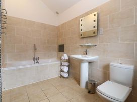 A bathroom with a bathtub and sink at Winsall Court II Gransmoor near Bridlington