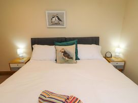 A bedroom with a bed and wall art at Bank Top Cottage in Embleton