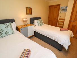 A bedroom with two beds and a nightstand at Bank Top Cottage Embleton