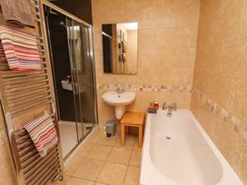 A bathroom with a bathtub and shower at Bank Top Cottage in Embleton
