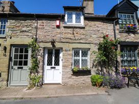 A stone cottage exterior with multiple doors and flowers at Chancery Cottage in Hay-On-Wye