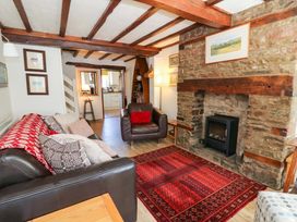 A living room with a fireplace and sofa at Chancery Cottage in Hay-On-Wye