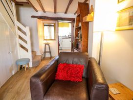 A living room with an armchair and a staircase at Chancery Cottage in Hay-On-Wye