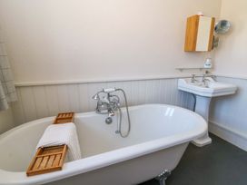 A bathroom with a bath tub and a sink at Chancery Cottage in Hay-On-Wye