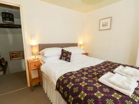 A bedroom with a bed and bedside table at Chancery Cottage in Hay-On-Wye