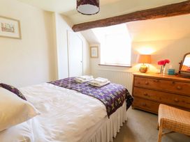 A bedroom with a bed and dresser at Chancery Cottage in Hay-On-Wye
