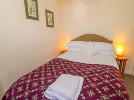 A bedroom with a bed and wall art at Chancery Cottage Hay-On-Wye