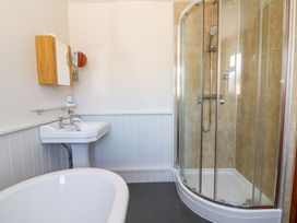 A bathroom with a bathtub, sink, and shower at Chancery Cottage in Hay-On-Wye