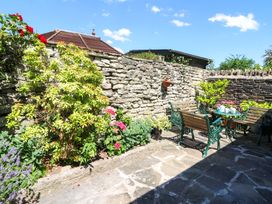 A garden with benches, table, and flowers at Chancery Cottage, Hay-On-Wye