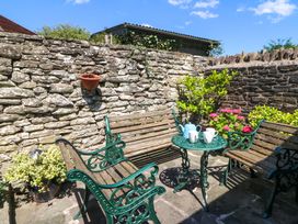 A garden seating area with a stone wall at Chancery Cottage in Hay-On-Wye