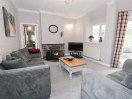 A living room with a fireplace and television at Dyffryn Bach in Glan-yr-afon near Corwen
