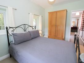 A bedroom with a bed and wardrobe at Dyffryn Bach in Glan-yr-afon near Corwen