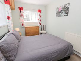 A bedroom with a bed, dresser, and chair at Dyffryn Bach in Glan-yr-afon near Corwen