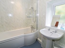 A bathroom with a bathtub and washbasin at Dyffryn Bach near Glan-yr-afon near Corwen