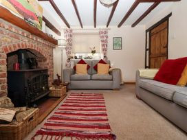 A living room with a fireplace and sofas at Clara's Cottage near Malton